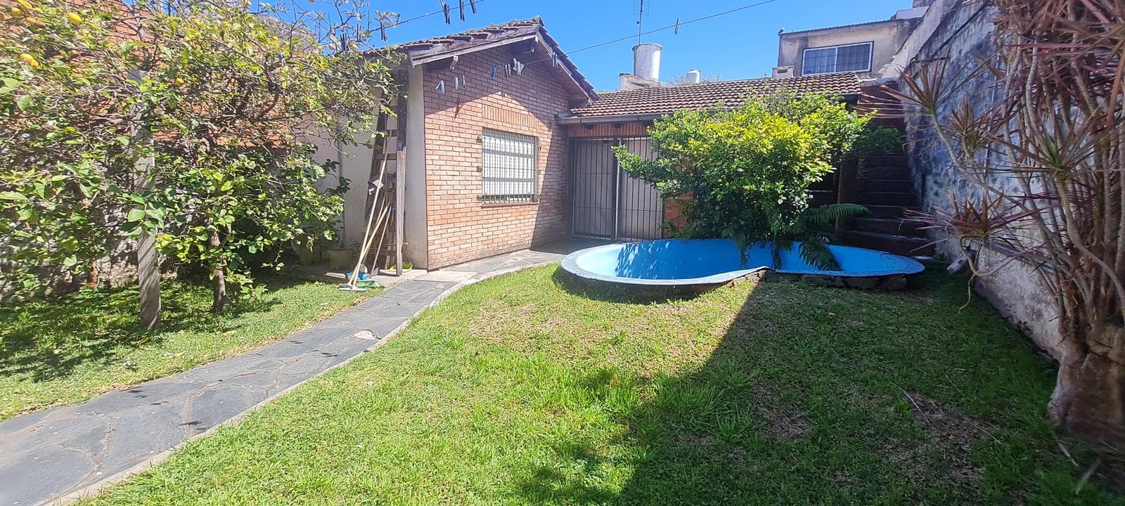 Lote con dos viviendas, jardín y cochera en Florida Oeste- En Venta